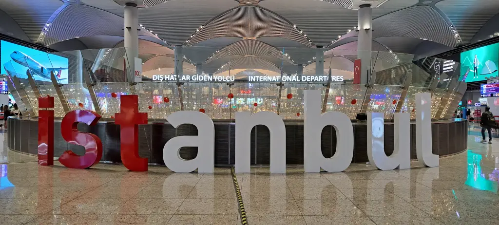 Departures terminal at Istanbul Airport with travellers and signage